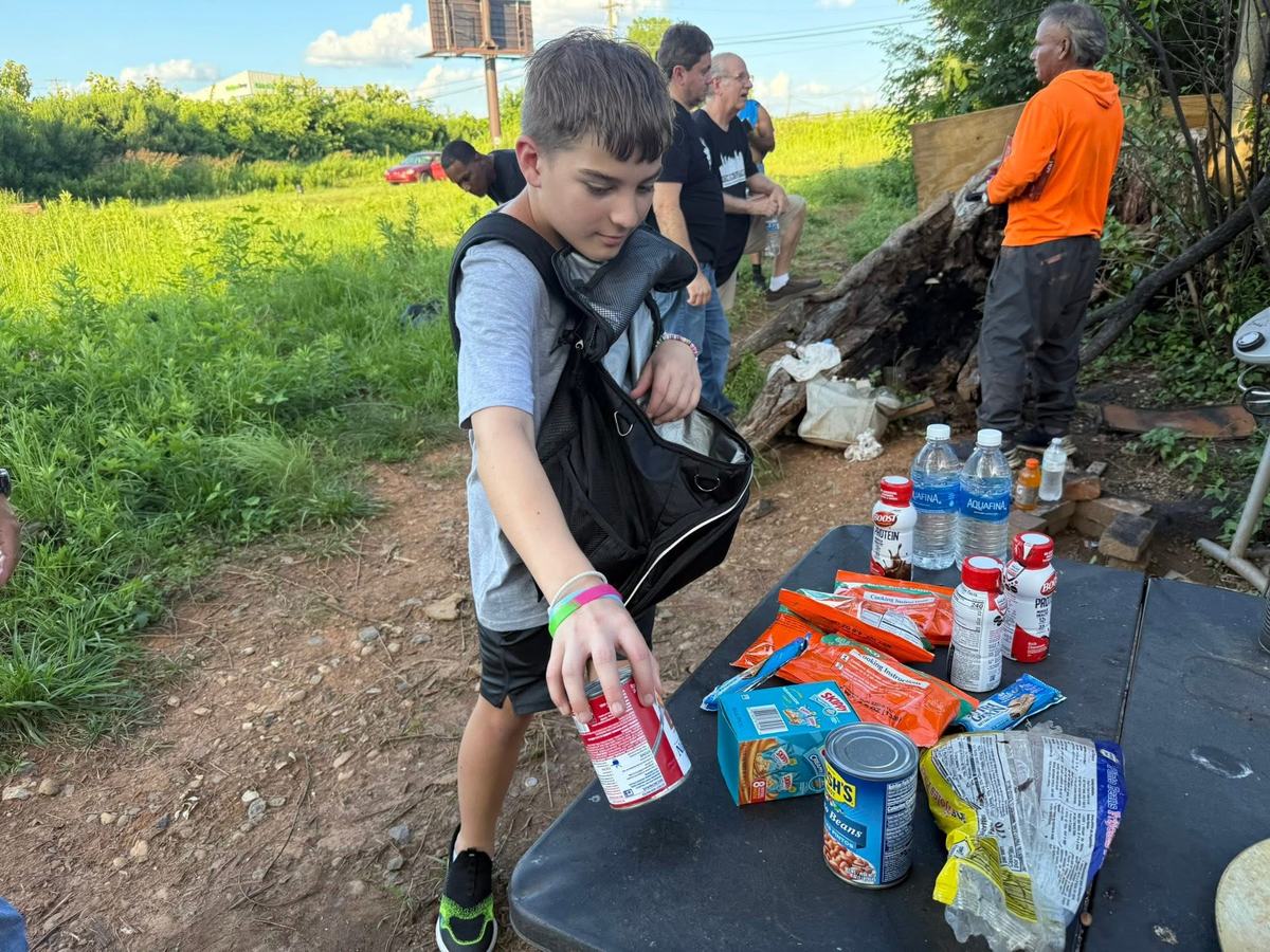 A volunteer setting out water and food at a camp